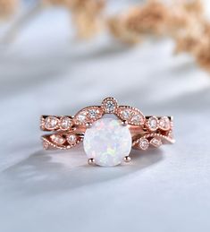 a white opal and diamond ring on top of a table