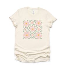 Looking for a cute versatile top to wear this summer? Make sure to grab one of our Wavy Checkered Flowers tees! This soft and comfortable graphic tee is the perfect top for any outfit. It can be paired with biker shorts, jeans, or even a simple skirt/dress! This tee is true-to-size, so be sure to order your regular t-shirt size! If you are looking for a more oversized look, make sure to size up! Trendy Cotton T-shirt With Retro Print, Casual Relaxed Fit T-shirt With Retro Print, Cute Spring T-shirt With Sublimation Print, White Retro Print Top For Summer, Cute Graphic Design Tops For Summer, Summer Retro Print Relaxed Fit T-shirt, Summer Retro Print Graphic Tee Tops, Summer Retro Print Graphic Tee, Summer Graphic Tee With Retro Print