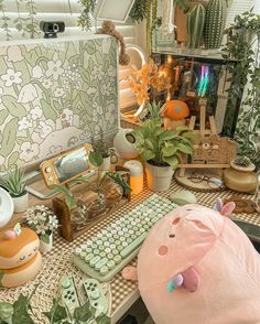 a desk topped with lots of plants and stuffed animals