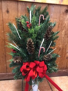 a vase filled with pine cones and candy canes