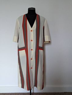 "A very nice lightweight vintage dress for the summer from Marie-Celine The dress is a loose button up coat dress or shirt dress style. It has two patch pockets on the front and has short sleeves. Beige with orange and brown stripes There is no size label but measures 40\" around the bust and as it is a straight down style, the waist also measures 40\" Good condition for its age and it still looks good Please ask for overseas postage so I can work out an accurate price" Retro Vintage Dress With Buttons For Daywear, Retro V-neck Dress With Button Closure, Retro Button-up Dresses For Daywear, Casual Vintage Dress With Buttons For Daywear, Vintage Buttoned Dresses For Beach, Mod Style Summer Dress With Buttons, White Retro Dress With Button Closure, Vintage Summer Dresses With Covered Buttons, Summer Mod Dress With Buttons