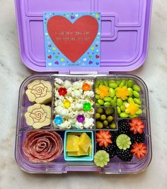 a purple lunch box filled with lots of food