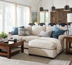 a living room filled with lots of furniture next to a large white couch and coffee table