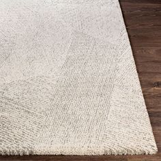 a large white rug on top of a wooden floor