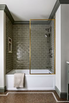 a bathroom with a tub, sink and mirror in the middle of the floor area