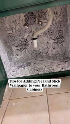 a bathroom with tile flooring and green cabinetry on the wall, in front of a toilet