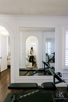 a woman sitting on a bench in front of a mirror