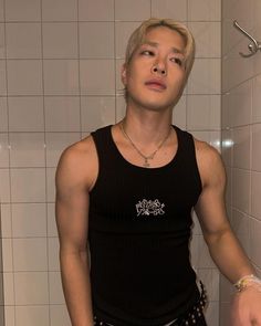 a young man standing in front of a shower