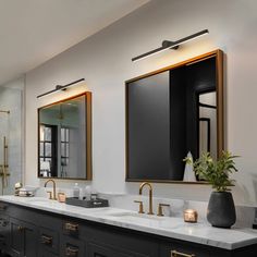 a bathroom with two sinks, mirrors and lights on the wall next to each other