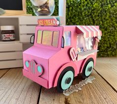 a pink toy truck sitting on top of a wooden table