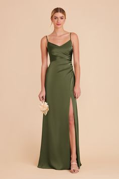 a woman in a long green dress with a slit down the side and her hand on her hip