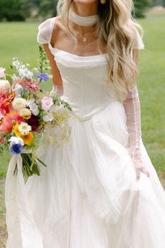 a woman in a white dress holding a bouquet of flowers