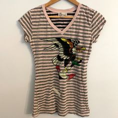 Ed Hardy Striped Eagle V-Neck Tee Pink + Black Striped Lightweight V-Neck With Eagle Graphic On Front / Eh Logo On Back. Tee Is Extra Long See Measurements 100% Cotton Nwot Factory Flaw: Misprint Of 2 Lines On Front-See Last Pic Women's Size: Medium Approximate Measurements: Bust: 18" Shoulder To Hem: 26" Similar To Von Dutch Y2k 90s 00s Eh18 #Edhardyoriginal #Calistyle #Tattoo #Retrostyle #S Cali Style, 90s 00s, Ed Hardy, V Neck Tee, Black Stripes, Retro Fashion, Black Pink, Womens Sizes, V Neck