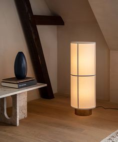 a lamp that is sitting on top of a table next to a book and some books