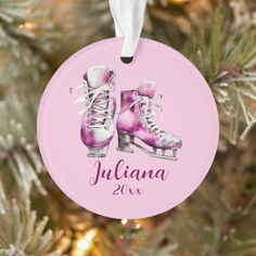 a personalized ornament hanging from a christmas tree with ice skates on it