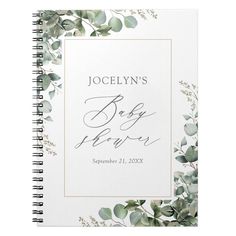 a spiral notebook with eucalyptus leaves and greenery