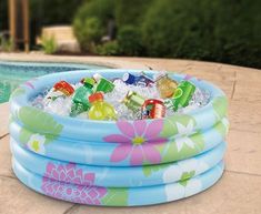 an inflatable pool is filled with drinks and sodas next to a swimming pool