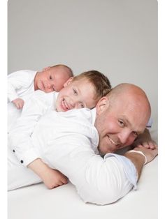 a man and two children are laying on the floor with their arms around each other