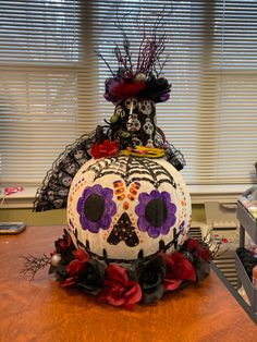 a decorated pumpkin sitting on top of a wooden table