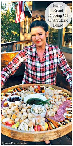 a woman sitting in front of a platter full of food