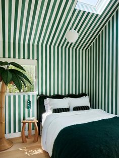 a bedroom with green and white striped walls