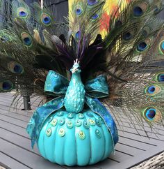 a peacock sitting on top of a blue pumpkin