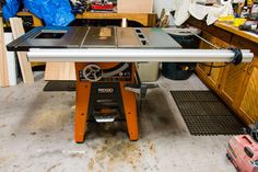 a table sawing on top of a machine in a room filled with wood cabinets