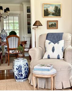 a living room with blue and white decor on the walls, furniture and pictures above