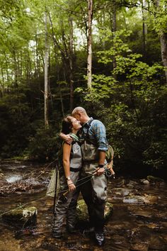 a man and woman kissing in the woods