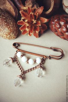 a pair of earrings sitting on top of a table next to some other items and a pine cone