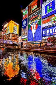 a river running through a city with lots of tall buildings in the background at night