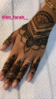 a woman's hand with henna tattoos on it