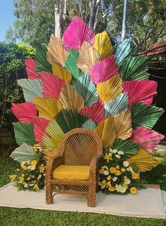 a chair sitting on top of a lush green field next to a flower covered tree