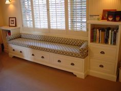 a living room with a couch, book shelf and bookshelf in the corner