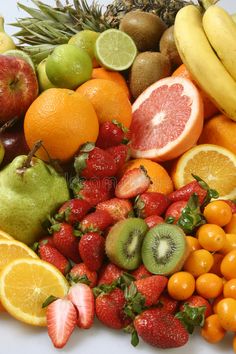 an assortment of fruits including oranges, strawberries, kiwis and apples