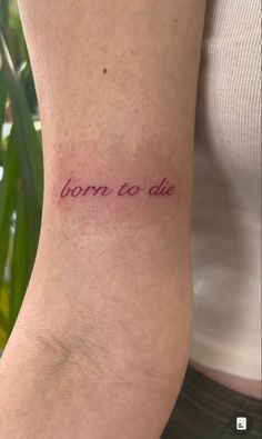 a woman's arm with the words born to die tattooed on her left side