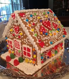 a decorative gingerbread house on a silver platter