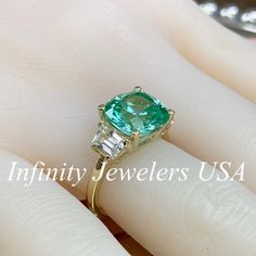 "Paraiba Tourmaline Ring, Cushion Cut Paraiba Engagement Ring, 14K Gold, Paraiba Tourmaline, Unique Engagement Ring, Three Stone Ring, #6256 This ring is a cushion cut lab created green paraiba with white sapphire trapezoid sides, 14k yellow gold #6256 We feature the finest quality of lab grown stones in the world. The properties of lab-grown are physically, chemically and visually identical to natural, just grown in a lab setting. -Approximate total carat weight: 6.20ctw diamond equivalent -Cen Gia Certified Tourmaline Jewelry For Anniversary, Green Sapphire Ring Gia Certified For Wedding, Wedding Gia Certified Tourmaline Ring, Gia Certified Tourmaline Jewelry For Gift, Gia Certified Tourmaline Wedding Ring, Gia Certified Green Oval Wedding Ring, Heirloom Green Sapphire Ring With Center Stone, Gia Certified Oval Moissanite Emerald Ring, Gia Certified Green Cushion Cut Rings