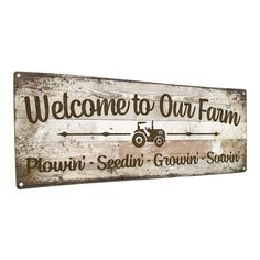 a wooden sign that says welcome to our farm with a tractor and arrow on it