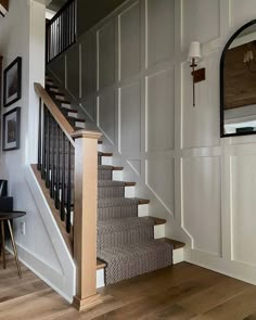 the stairs are made of wood and have metal railings on each side, along with carpeted flooring