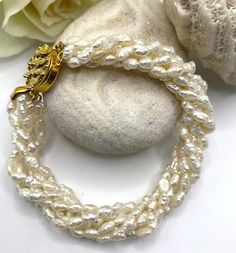 Luxurious twisted pearl bracelet made with no less than 6 rows of top quality natural freshwater pearls. This elegant piece is finished with a secure clasp featuring a delicate gold design that will add a touch of luxury to any outfit. Also perfect to wear as bridal jewellery or as a gift to your bridesmaids! Please note that this beautiful piece can also be bought as part of a necklace&bracelet set available from our shop. This original design was handcrafted with love in my London studio. I ho Baroque Pearl Beaded Bracelets For Wedding, Wedding Baroque Pearl Beaded Bracelets With Pearl Drop, Wedding Baroque Pearl Beaded Bracelet With Pearl Drop, Multi-strand Pearl Bracelet As Gift, Wedding Bracelets In Pearl White Baroque Pearl, Pearl White Baroque Pearl Bracelets For Wedding, Wedding Baroque Pearl Beaded Bracelets In Pearl White, Wedding Baroque Pearl Bracelets In Pearl White, Wedding Baroque Pearl Beaded Bracelets