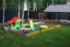 an outdoor play area with swings, slides and playset in the grass next to trees