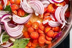 onions, tomatoes and lettuce are being cooked in a pot