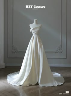 a wedding dress on display in front of a white wall with the words hey couture