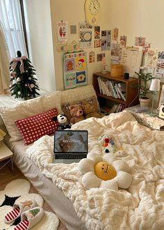 there is a laptop on the bed with teddy bears and other decorations in the room