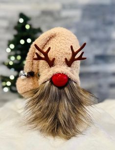 a knitted reindeer hat with red nose and long hair