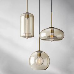 three glass pendant lights hanging from a ceiling