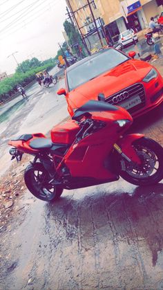 an orange motorcycle parked next to a red car