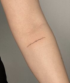 a woman's arm with a small tattoo on the left side of her arm