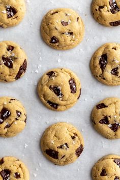 chocolate chip cookies are lined up on a baking sheet